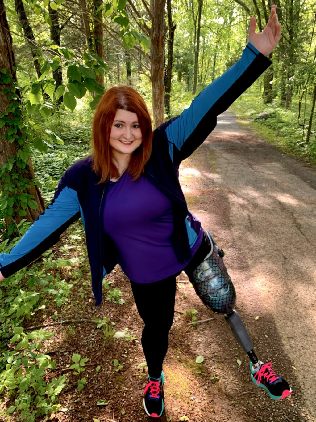 Amputated woman standing in the forest on one leg wearing the prosthetic foot Xtend Foot